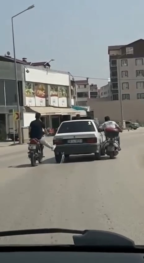 Bursa’da motosiklet sürücüleri yolda kalan otomobili ayaklarıyla ittiler