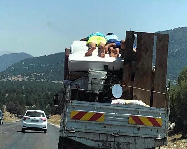 Eşya yüklü kamyonetin kasasındaki yatakta tehlikeli yolculuk