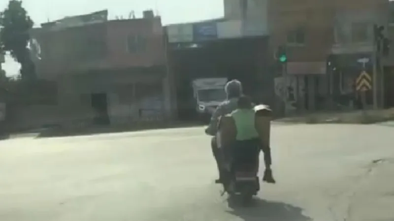 Motosiklette karton koliye asılan çocuğun tehlikeli yolculuğu kamerada