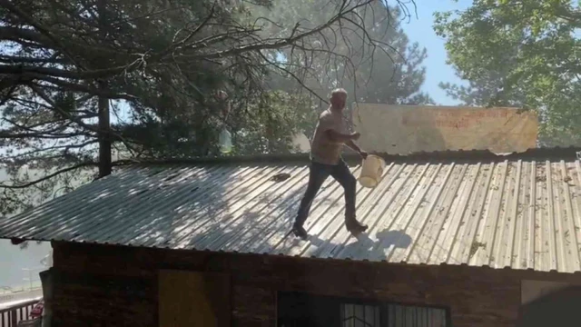 İnekleriyle belediyeyi basmıştı...Şimdi de benzin bidonuyla çatıya çıktı